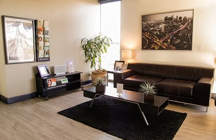 The lobby at Bixby Knolls Dental Group, with a sofa, reading and a Los Angeles skyline print.